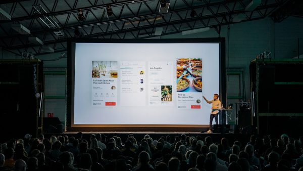 Corporate conference stage with presenter and large screen